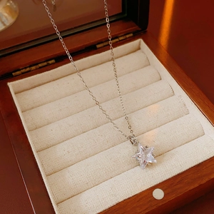 Vue macro du collier avec pendentif étoile en zircon argenté dans son écrin en bois