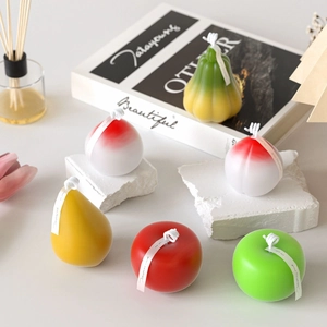 Vue détaillée de bougies réalistes en forme de fruits 3D pomme poire et pêche artisanales