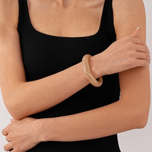 Close-up of geometric acrylic open bangle with retro tortoiseshell texture on female wrist