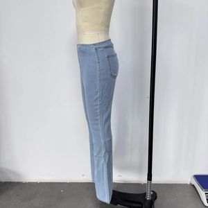 Détail du jean évasé bleu clair avec coupe ajustée montrant la poche latérale et la couture