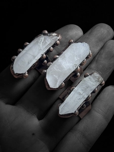 Detailed macro view of three vintage bronze rings with natural white quartz crystals