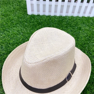 Detail of natural straw weave texture and brown leather strap with buckle on a fedora hat