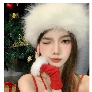 Detail of red knit gloves with white faux fur cuffs and a matching plush winter hat