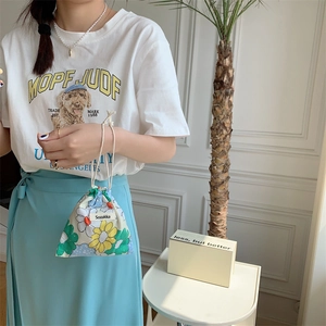 Detail of floral drawstring pouch showing small fabric storage bag in model's hand