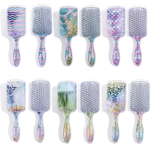 Flat lay collection of square hairbrushes featuring glitter sequins and colorful patterns