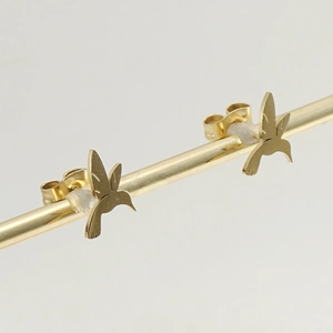 Macro shot of gold bird-shaped stainless steel stud earrings with secure backings
