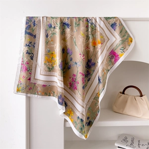 Détails de l'imprimé floral élégant et du drapé d'un foulard carré en soie beige