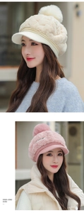 Detail view of winter knitted cap featuring plush faux fur pompom and textured pattern