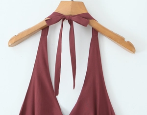 Detail of the halter neck tie with a bow knot on a burgundy summer mini dress