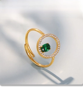 Detail of PVD gold plated ring featuring green oval gemstone and pavé crystal setting