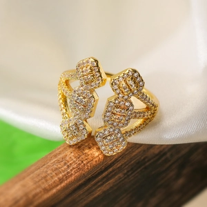 Luxurious gold-plated geometric open ring with shimmering cubic zirconia on dark wood