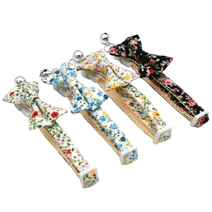 Floral pet collars with bows and bells in green, blue, yellow and black patterns
