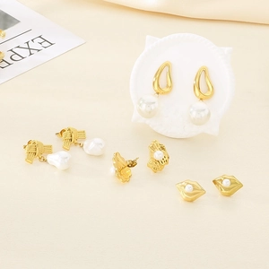 Set orecchini dorati con perle e perni a forma di labbra su sfondo color crema