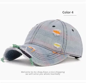 Detail of distressed denim baseball cap with rainbow stitching and frayed edges