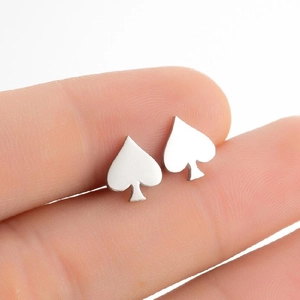 Close-up of a silver spade-shaped stainless steel stud earring held by fingers