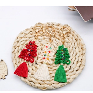 Detail of handmade cotton rope woven Christmas tree keychains with colorful bead accents