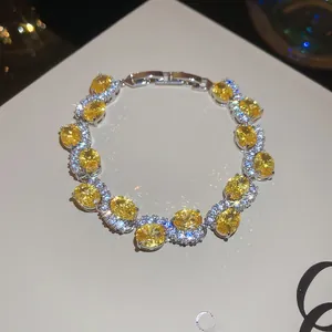 Macro shot of silver bracelet featuring oval yellow zircons with sparkling white diamonds