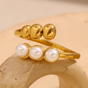 Detail view of an adjustable gold-plated ring featuring three gold beads and three pearls