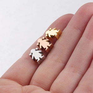 Three girl-shaped stainless steel beads in gold, rose gold, and silver on a finger