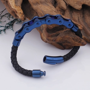 Detail eines blauen Metall-Fahrradketten-Armbands mit schwarzem Leder auf weißem Grund