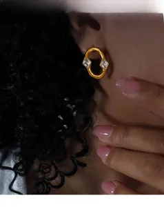 Detailed view of matte gold earrings with square-cut cubic zirconia on a female model