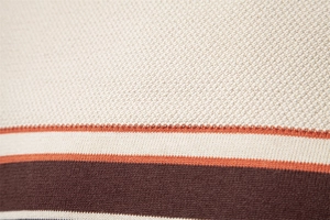 Detailed macro view of cream, orange and brown striped knit fabric texture on sweater