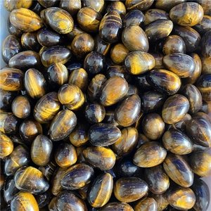 Macro view of multiple 30mm tiger eye egg stones with natural yellow brown stripes