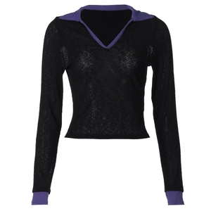 Détail du col en V avec liseré violet contrasté sur un haut en maille noir à manches longues