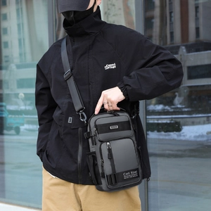 Outdoor shot of a versatile dark grey nylon crossbody chest bag with adjustable strap