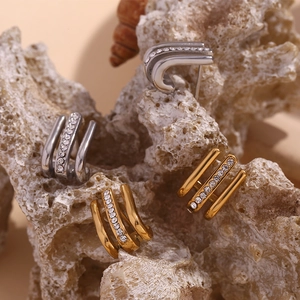 Detailed shot of gold and silver triple-layered U-shaped earrings with rhinestones
