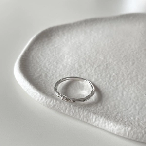 Minimalist 925 sterling silver ring with champagne zircon stones on ceramic tray