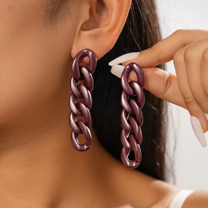 Close-up of deep purple acrylic chain link earrings worn by a model in a minimal setting