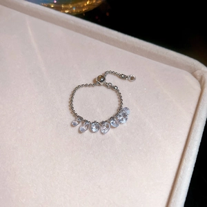 Close-up of adjustable silver chain ring with seven pear-cut zircons in a velvet box