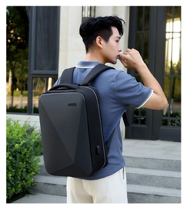 Detail of black hard shell backpack with geometric facets and external USB charging port