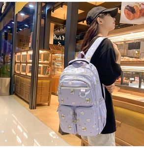 Close-up of purple backpack with cute bear print and multi-pocket design on model