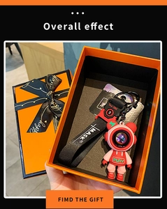 Detailed view of a pink astronaut bear keychain inside a stylish orange gift box