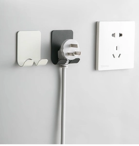 Macro detail of wall-mounted plug holders in matte black and white aluminum finish