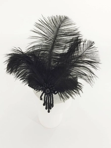 Detailed view of 1920s black feather headband with beaded fringe on white model head