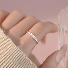 Close-up of a silver chain link ring on finger with pink zircon and heavy metal style