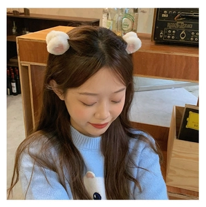Pair of cute plush white cat ear hair clips with pink inner detail worn by a model