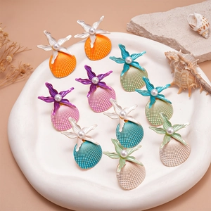 Starfish and pearl shell stud earrings in various beach-inspired colors on a tray