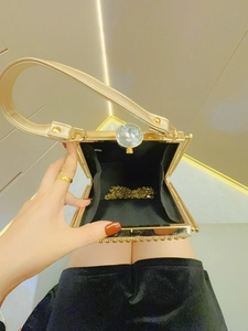 Golden evening clutch bag with sparkling crystal clasp and detachable metal chain strap