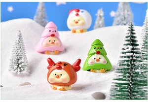 Detailed view of four resin Christmas chick figurines in a miniature winter snow scene
