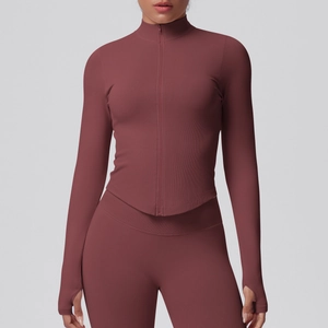 Detailed close-up of terracotta yoga jacket showing thumbholes and rib-knit texture