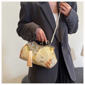 Detail of Chinese style shell bag with floral embroidery, pearl chain, and long tassel