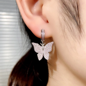 Close-up of elegant silver butterfly earrings set with sparkling pink zircon stones