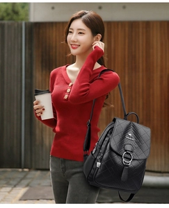 Détail du sac à dos en cuir matelassé noir avec boucle métallique et logo kangourou
