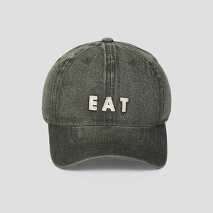Detail of white EAT letter embroidery on vintage washed grey denim baseball cap