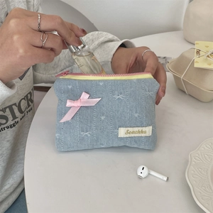Dettaglio della mini borsa in denim con fiocco rosa e ricamo per piccoli oggetti