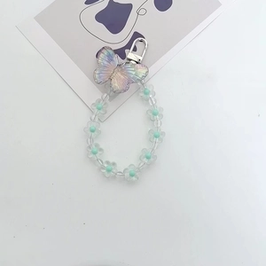 Macro view of colorful butterfly pendant and transparent floral beads with alloy clasp